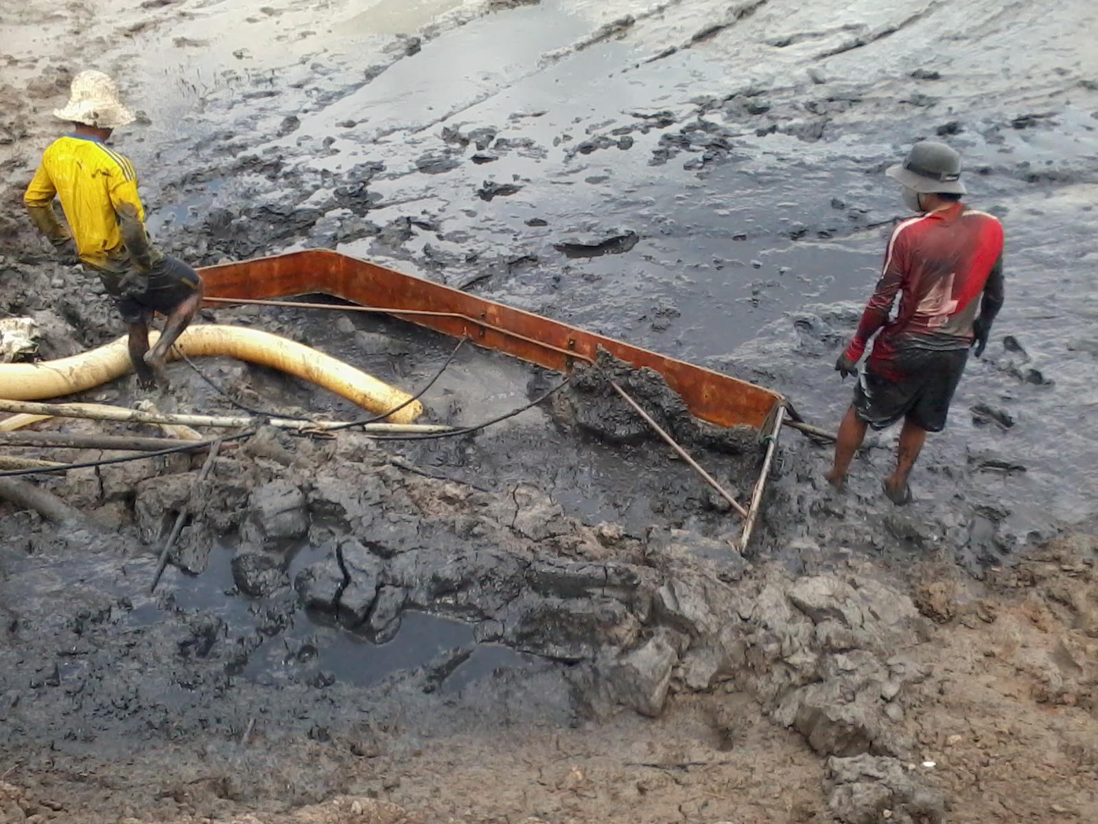 công nhân xử lý bùn